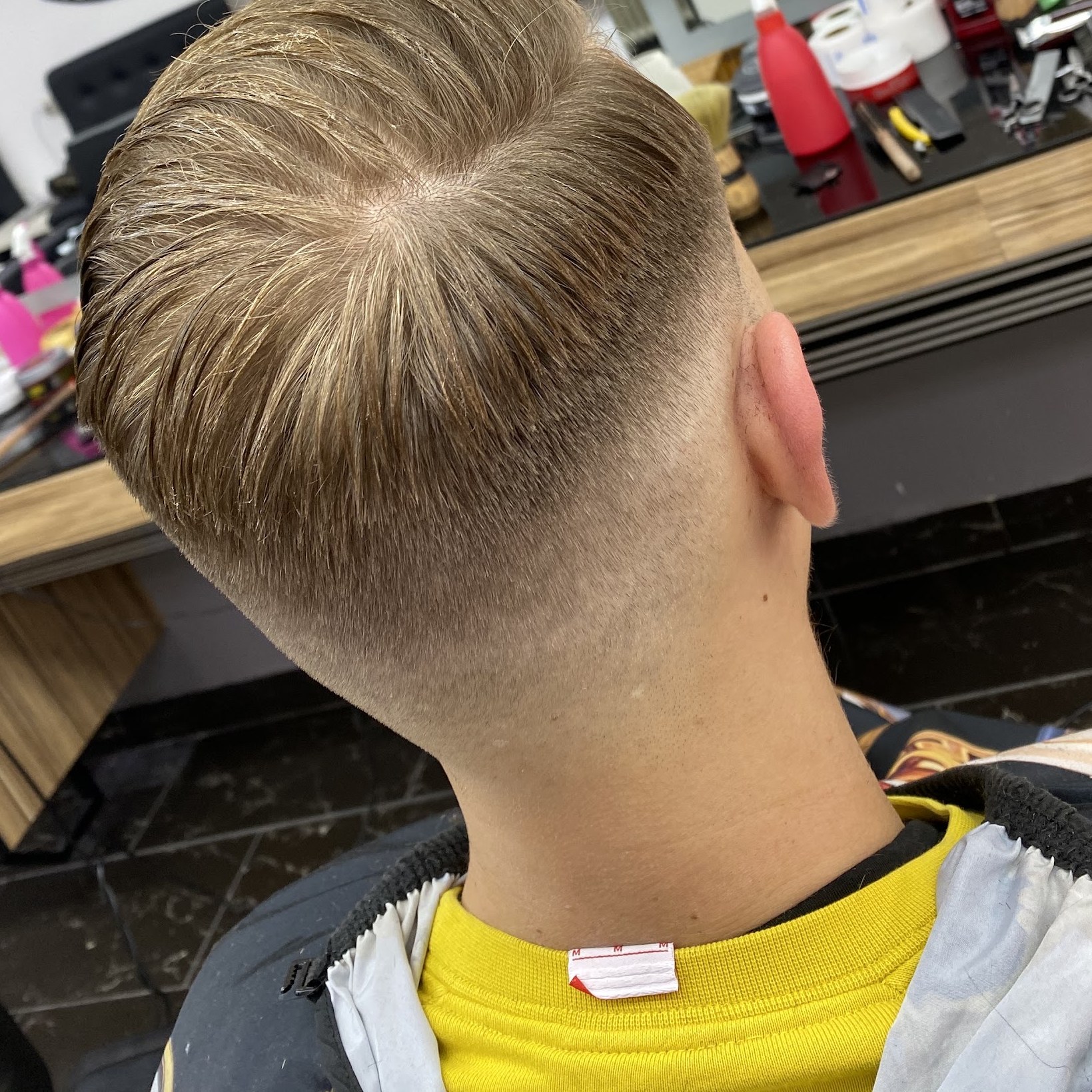 Een fade van achteren gezien, net geknipt bij Barber Adwar
